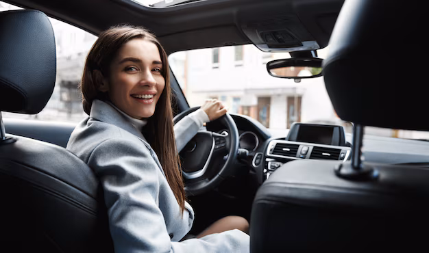 elegant-woman-driver-looking-backseat-smiling-happy_197531-22676.avif